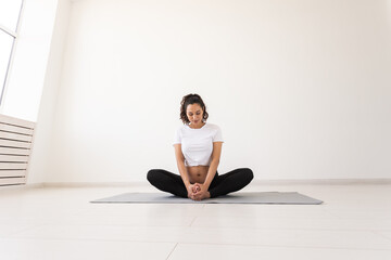 Purposeful pregnant woman exercises during yoga class and relaxes while sitting on a mat on the floor. Concept of physical and mental preparation of the body for childbirth. Place for text