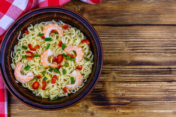 Instant noodle with shrimps, red pepper and green onion in a ceramic bowl. Japanese food. Top view