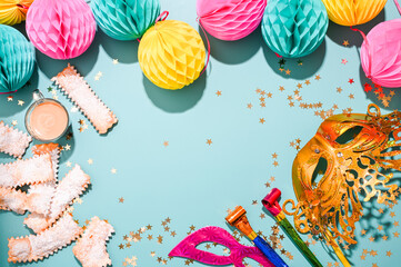 Traditional Venetian carnival and food TYPICAL. Sfrappole or chiachiere or angel wings on a bright blue background. carnival masks and tinsel. Copy space