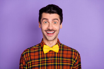 Photo of excited funny guy shiny white smile open mouth wear bow tie checkered shirt isolated purple background