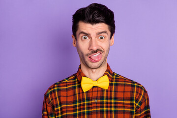 Portrait of attractive brunet funky guy wearing checked shirt grimacing dislike reaction isolated over violet purple color background