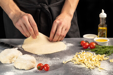 Step by step instructions for making homemade noodles. The cook is cutting the dough. Wooden background.