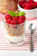 Yogurt with granola and fresh blueberries and raspberry, in glass. Healthy breakfast: yogurt parfait with granola and berries