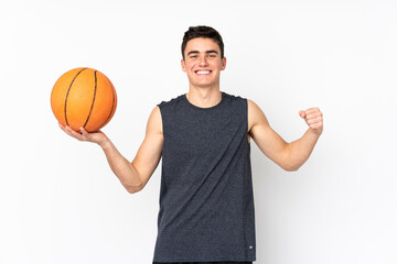 Handsome young basketball player man over isolated wall playing basketball