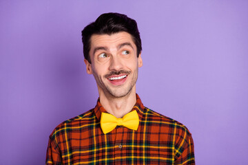 Photo of minded smart guy look empty space think wear bow tie checkered shirt isolated violet background