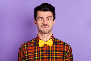 Photo of funny childish young man dressed checkered shirt bloated cheeks looking nose isolated purple color background