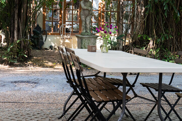 Fototapeta na wymiar Picnic a a garden, Wooden Chairs and White Table