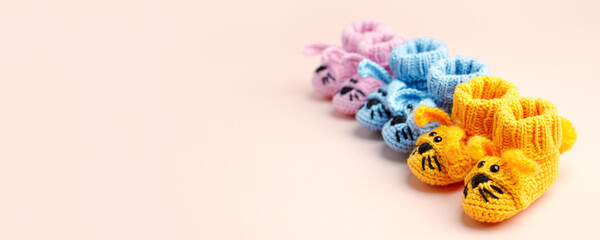 Pregnancy motherhood perenthood concept, Three pairs of baby booties on pastel background, baby shower, first birthday party banner, handmade socks, daycare, kindergarten, nursery, mother mom