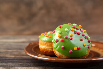 Bun, donut covered with glaze. Tutti frutti bun on a plate. Sweet pastries. Dessert. Copy space. Close-up.