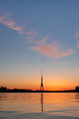 The tallest tower in the European Union - Radio and TV tower in Riga, Latvia during colorful sunrise over the Daugava river