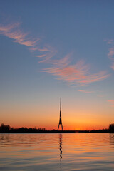 The tallest tower in the European Union - Radio and TV tower in Riga, Latvia during colorful sunrise over the Daugava river