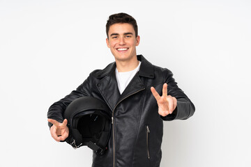 Man holding a motorcycle helmet isolated on white background smiling and showing victory sign