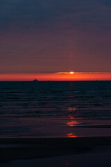 Fototapeta na wymiar Sunset in the Baltic sea in Liepaja. Ships on the horizon and calm sea