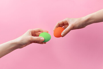 Woman hands holding Easter eggs for knocking on pink background. Easter celebration or creative concept. Adam creation