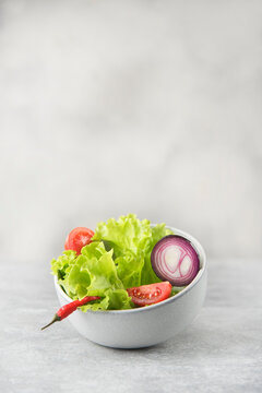 bowl with fresh salad on gray stone background