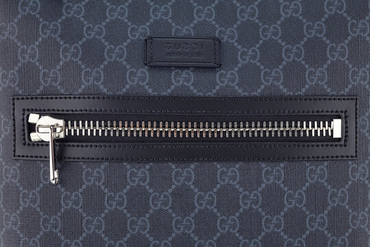  GUCCI logo, embossed on a black leather tag, serves as a decoration for leather bags with the logo arranged in a checkerboard pattern. Belarus, Minsk, 25.03.2021.