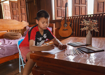 Fototapeta na wymiar .A boy sitting at his house drawing and painting.
