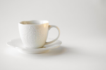 Drunk cup of strong coffee with coffee spent grounds on saucer with spoon against white background, top view with place for text