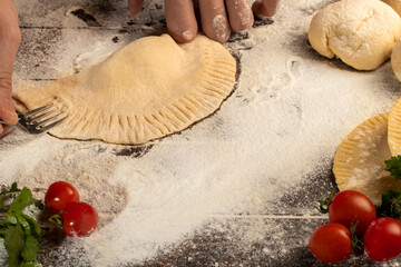 The cook prepares pasties. Step-by-step instruction. Forms the dough. Wooden background.