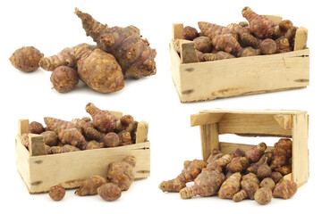bunch of topinambur roots (helianthus tuberosus) and some in a wooden crate on a white background