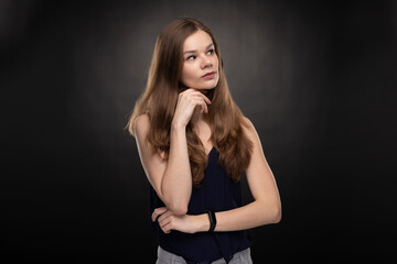 Young woman - student with smartwatch - looking right - studio shoot on the black background 