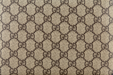 Print impression with the GUCCI logo in black on a linen textile fabric. Belarus Minsk 25.03.2021. Horizontal image. Stock Photo Adobe Stock