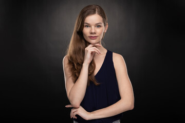 Young woman - student with smartwatch - looking into the camera lens - studio shoot on the black background 
