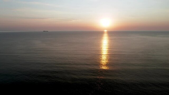 Aerial video over morning calm sea and beautiful sunrise with reflections.