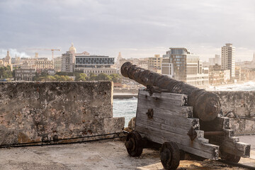 Close up Shot Old Rusty Cannon Against Skyscraper Buildings And Sky In Havana, Cuba At Sunny Day. - 423730776