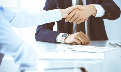 Fototapeta na wymiar Business people or lawyers shaking hands finishing up a meeting, close-up. Negotiation and handshake concepts