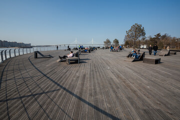 People sunbathing on the wood covering of the recreation zone on the coast of the Finnish Gulf in Saint Petersburg, Russia. 