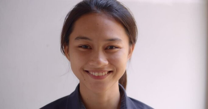A female teenage Asian high school student girl is smiling happily. 