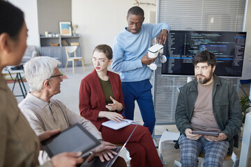 Naklejka premium High angle view at contemporary diverse business team sitting in circle during strategy meeting, focus on young businesswoman in center