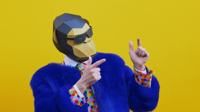 Man wearing funny masks and doing party. Celebrating and dancing over colored backgrounds