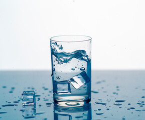 clear water spray in a glass with ice, clear water in a glass with spray