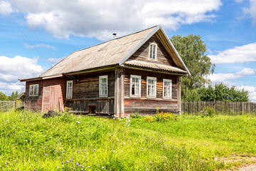 Fototapeta na wymiar Old rural wooden houses in abandoned russian village in summer sunny day