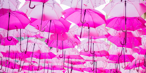 Fototapeta na wymiar Pink Umbrella Sky - View Of Umbrella Sky in Paris Royal Village. Located Near Madeleine Church is Very Charming And Filled With Luxury Shops.