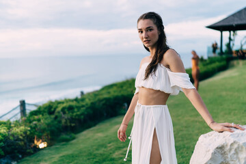 Fototapeta premium Serene woman in summer dress standing on seashore