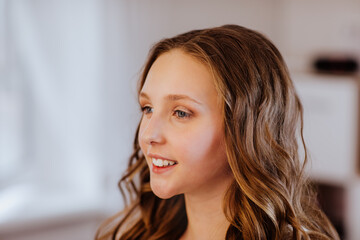 Portrait of pretty teen girl with curly hairdressing and light make up.