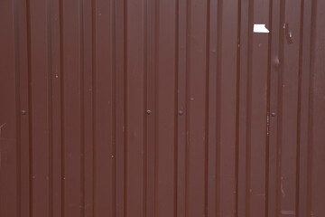 Fototapeta premium Background from a metal fence. Metal brown roof