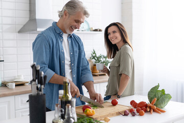 Couple cooking together in their kitchen at home.