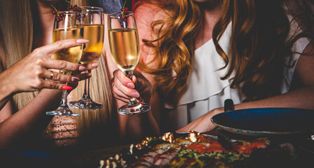 Women's hands with glasses of champagne wine. Clinking glasses of champagne in hands