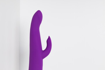 Violet dildo on a white background with room for text. Vibrator and masturbation. Sex shop