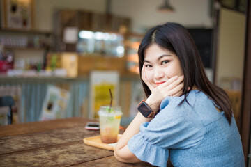 Beautiful women sittinfg in cafe with ice summer soda drink