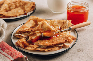 Homemade crepes with sea buckthorn jam and milk.