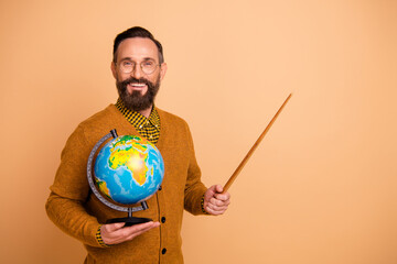 Photo of positive mature man teacher hold globe point pointer empty space wear pullover sweater...