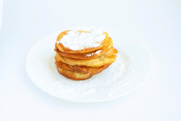 Fototapeta na wymiar Pancakes with powdered sugar on a plate, isolated on a white background