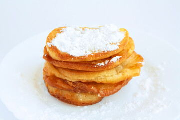 Pancakes with powdered sugar on a white plate