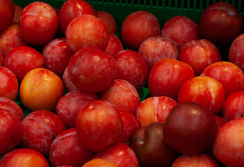 Fototapeta na wymiar Background of red plums in the grocery store