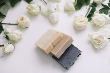 Handmade natural floral soap and roses on white background. Soap making. Soap bars. Spa, skin care. Natural Organic spa cosmetics on white table from above. flat lay, top view